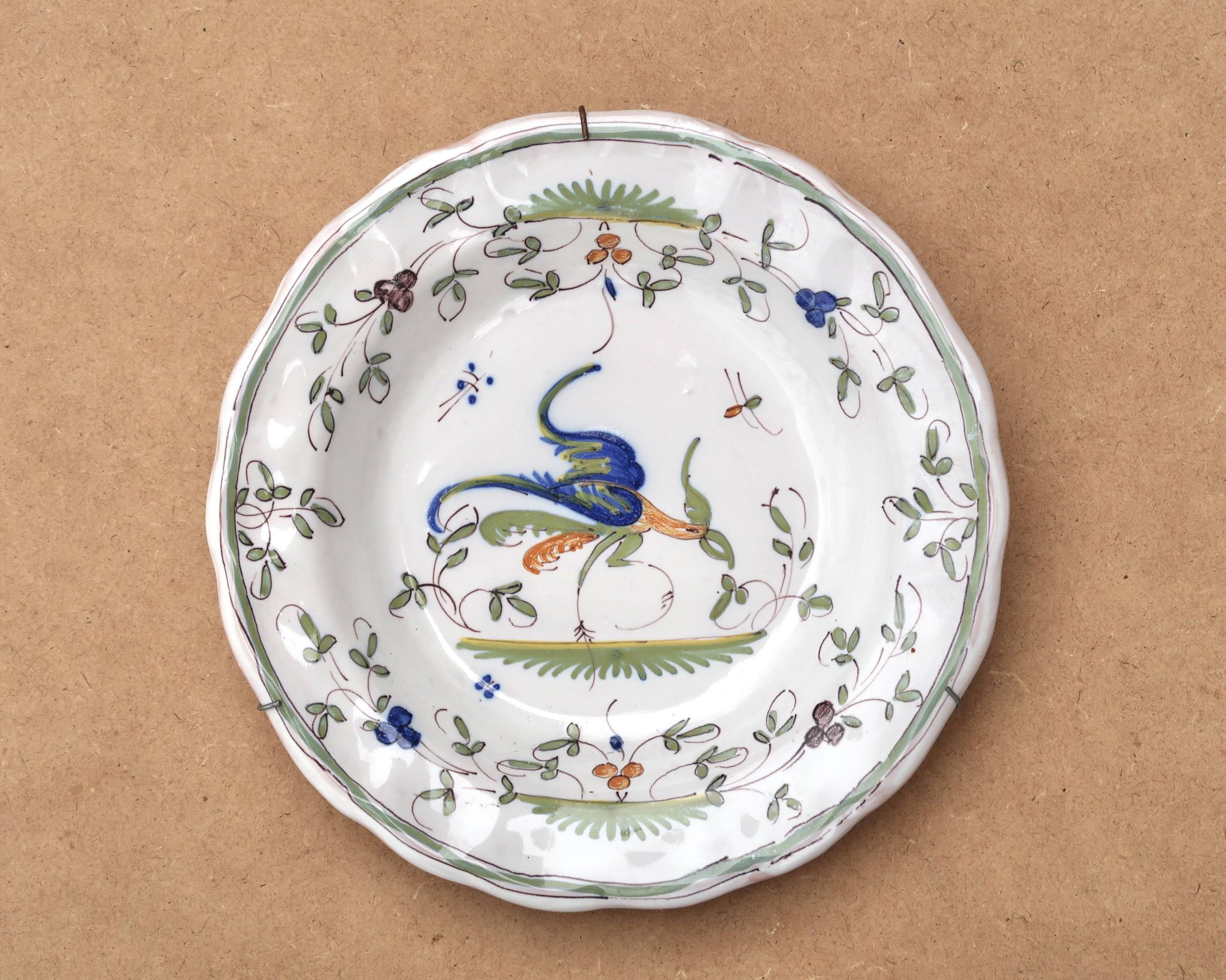 Hollow plate in Moustiers faience decorated with a bird, 19th century.