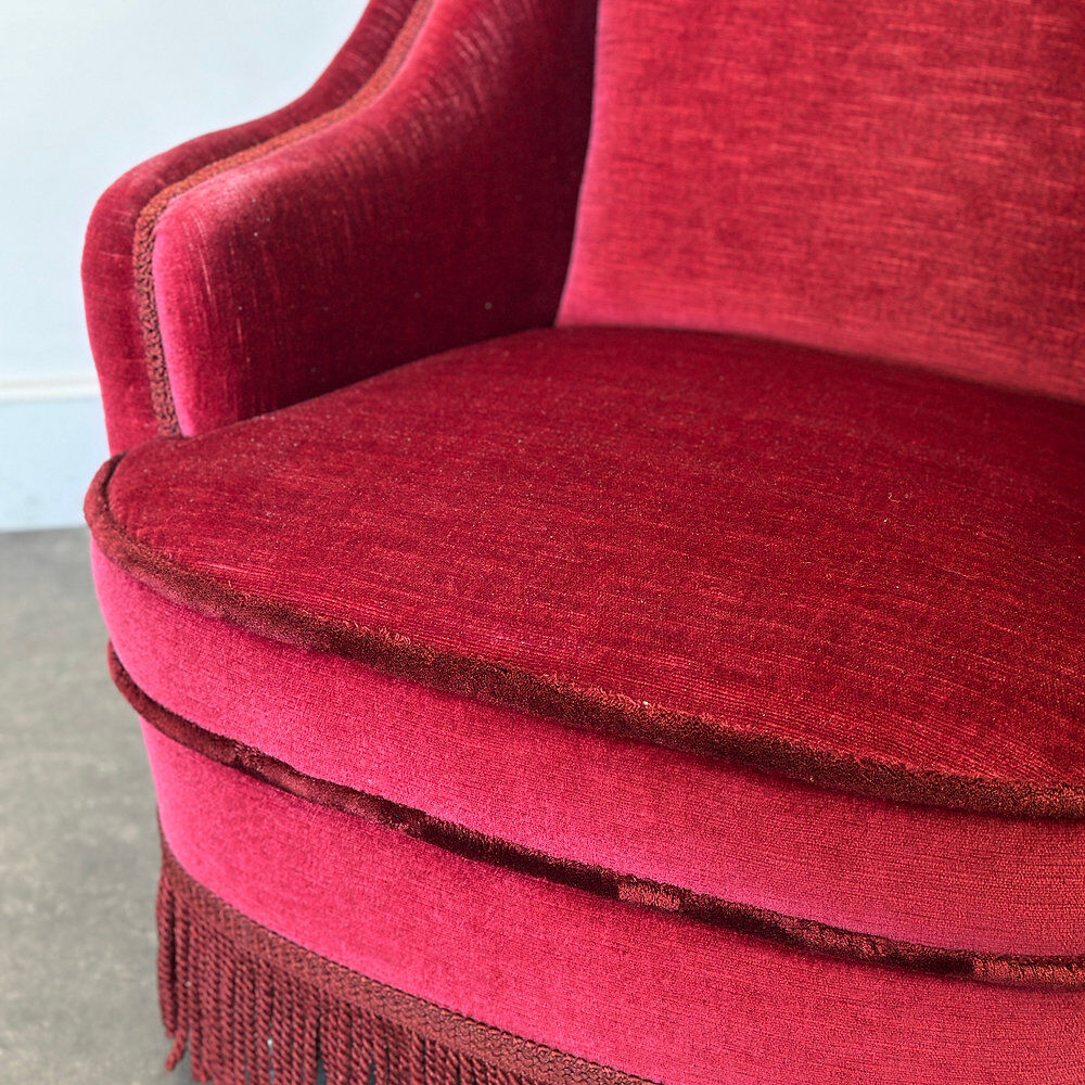 Paire de fauteuils de club vintage français en velours rouge profond avec jupe à franges, années 1960.