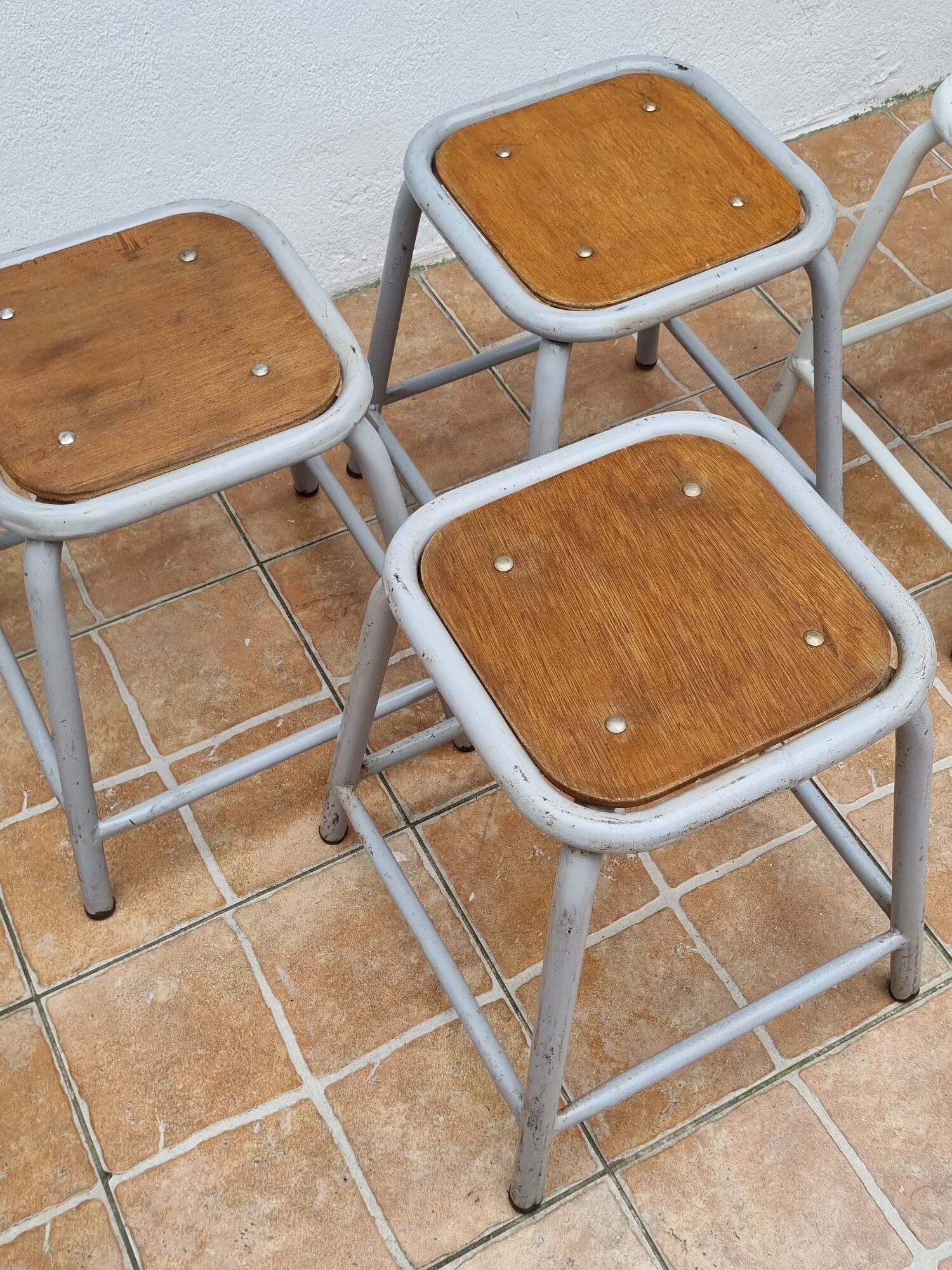 Set of four stackable industrial tubular metal and wood stools