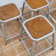 Set of four stackable industrial tubular metal and wood stools