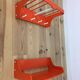 Space age wall coat rack, orange wood, with its shelf from the 1970s.