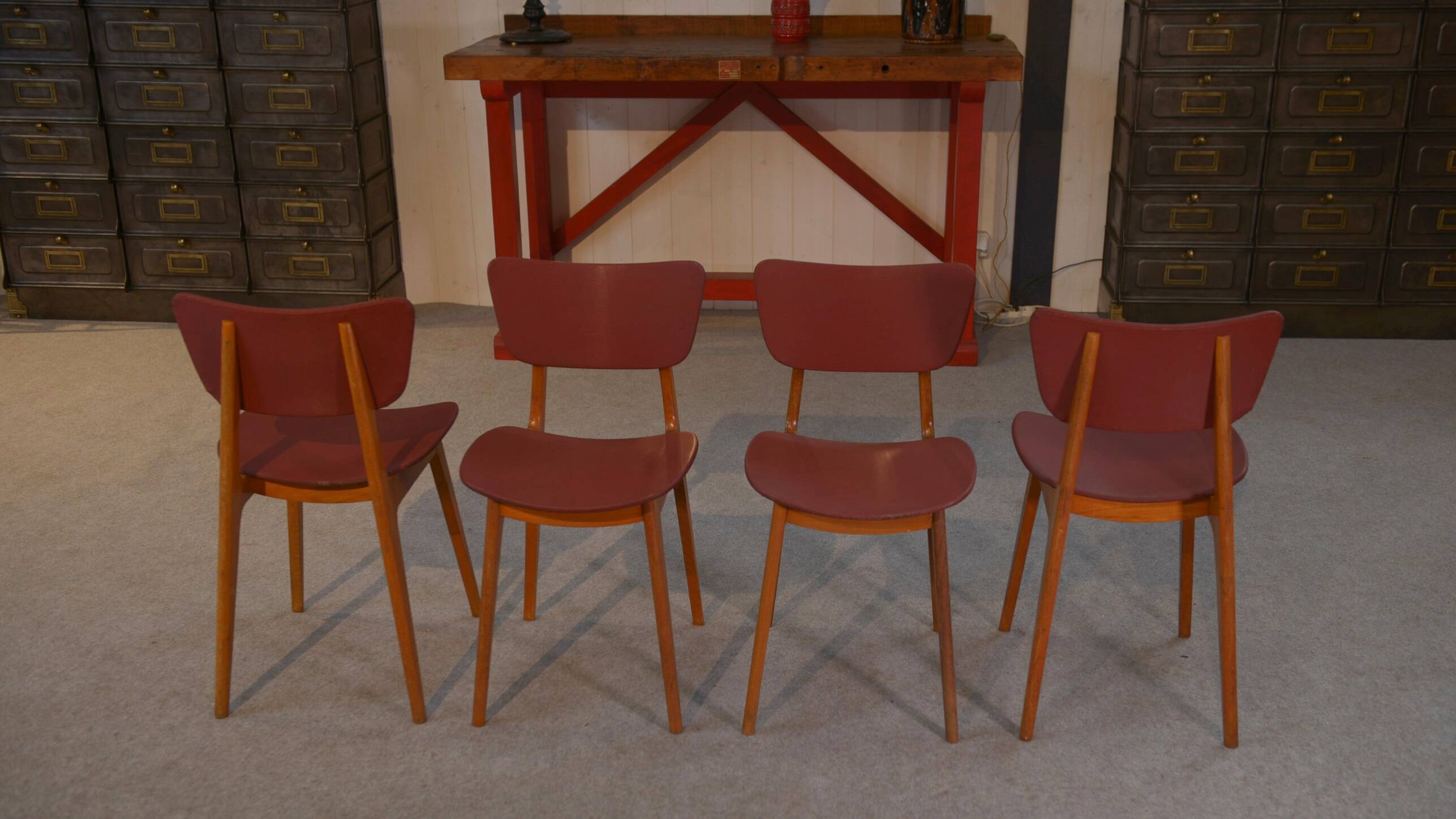 Set of 4 designer chairs in oak and red leatherette from the 1960s