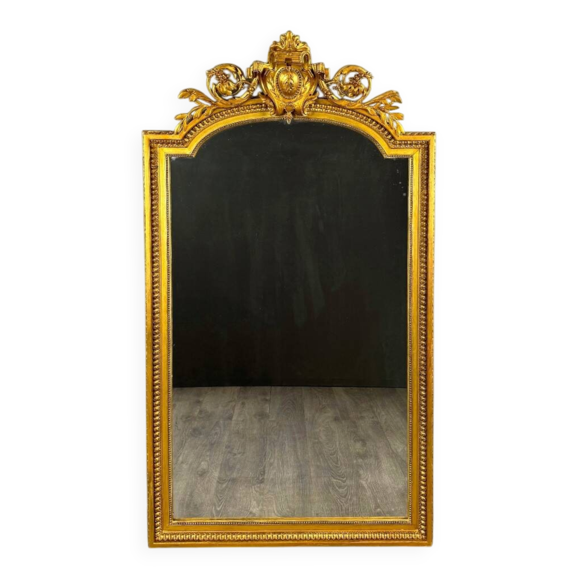 Large antique gilded wooden mirror in Louis XVI style with a sculpted pediment, 19th century.