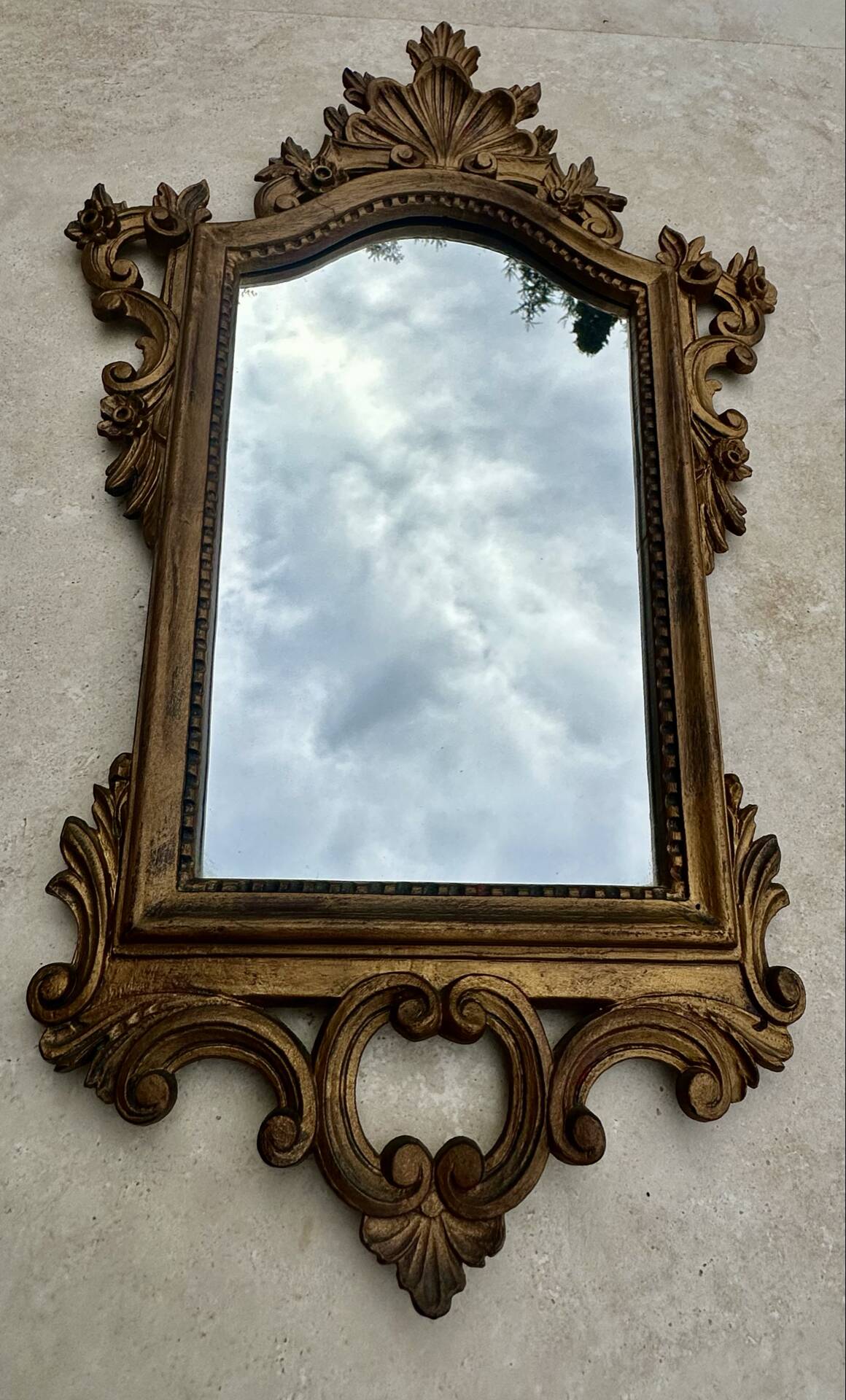 Carved and gilded wooden wall mirror.