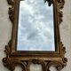 Carved and gilded wooden wall mirror.
