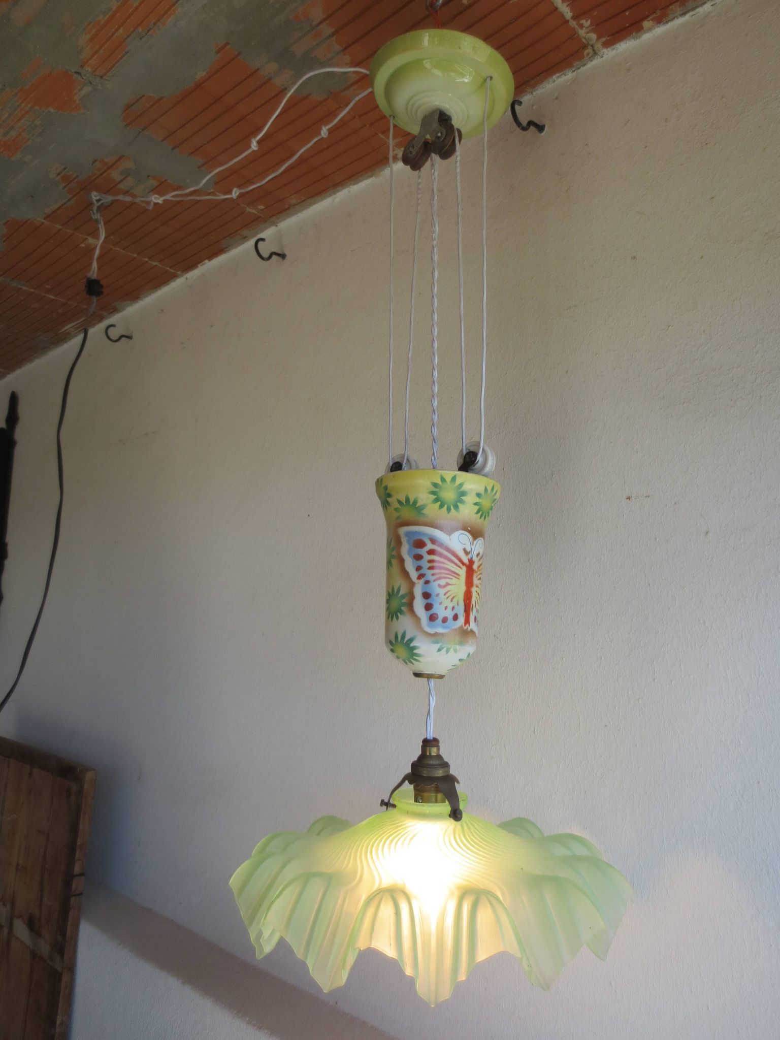 "Very old light fixture" with a "rise and fall" counterweight adorned with butterflies.