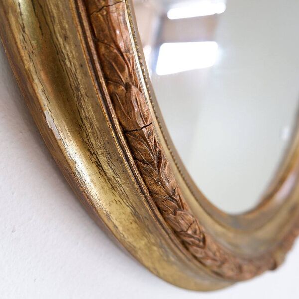 Wear consistent with age and use  Wood and gilded plaster ''Noeud d'Amour'' Oval mirror
