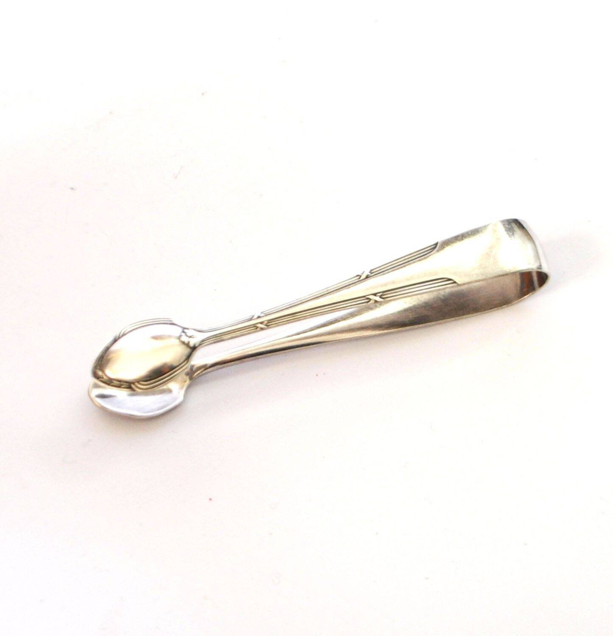 WMF vintage sugar tongs in silver-plated metal with crossed ribbon decoration.
