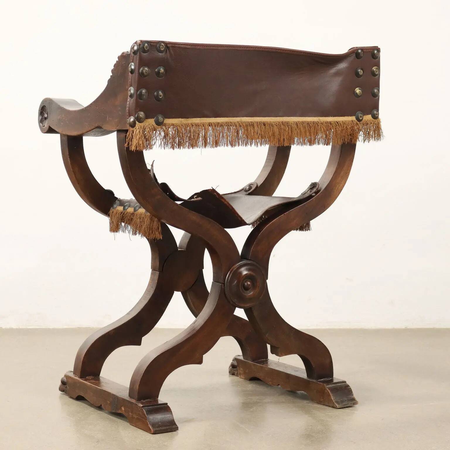 Antique neo-Renaissance folding chair in walnut and leather, Italy, 20th century.