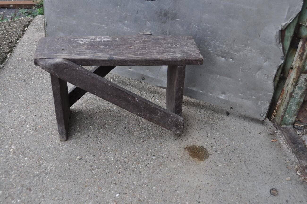 Low stool in vintage brown painted pine from the 1940s, with a rectangular seat.