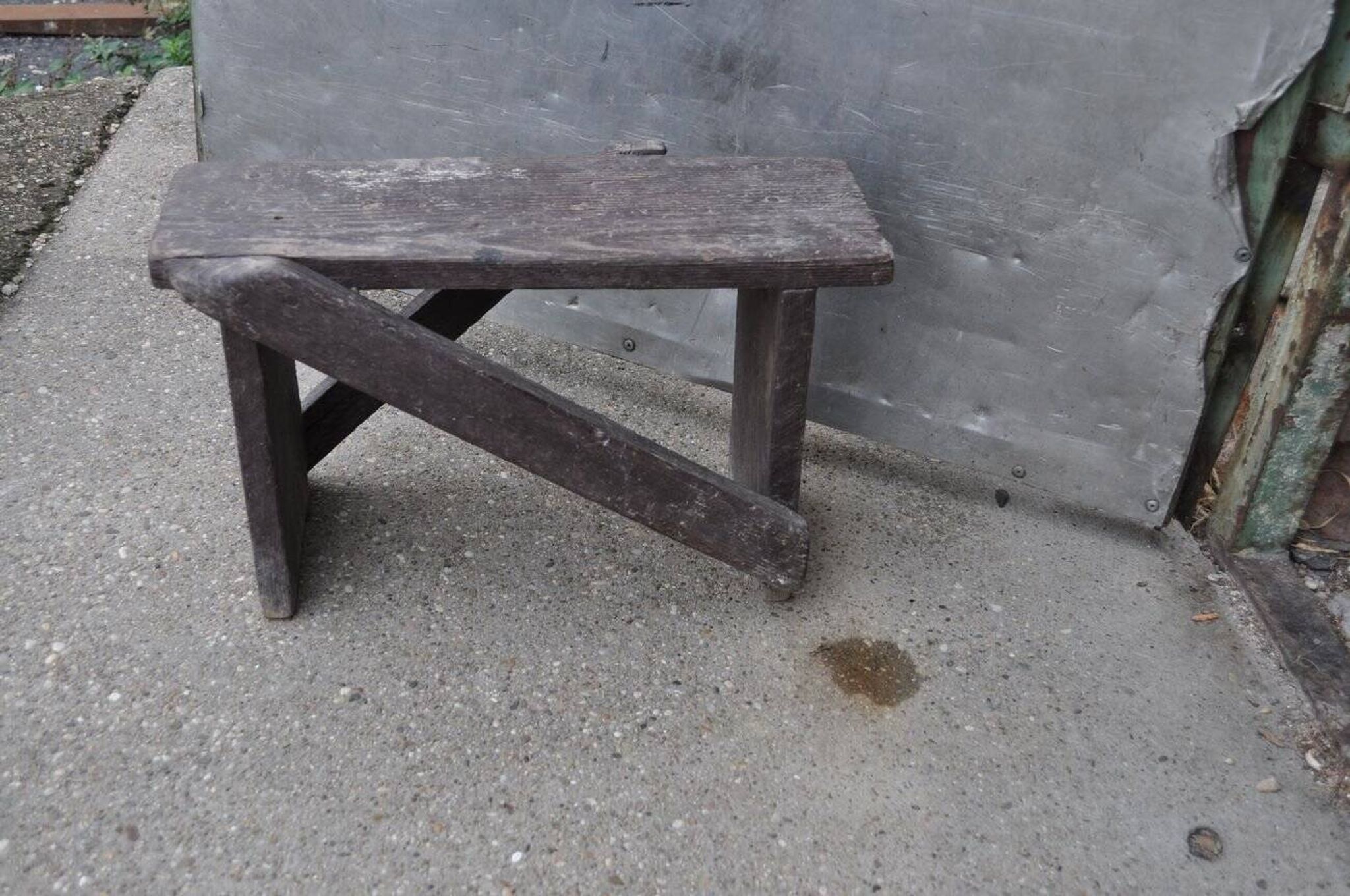 Low stool in vintage brown painted pine from the 1940s, with a rectangular seat.