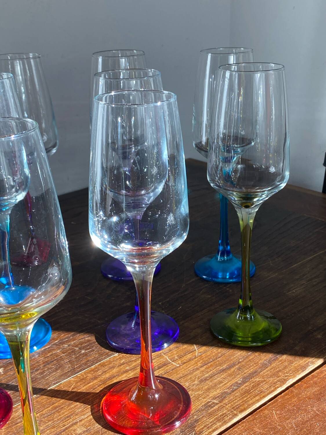 Champagne coupes in glass, multicoloured stems.