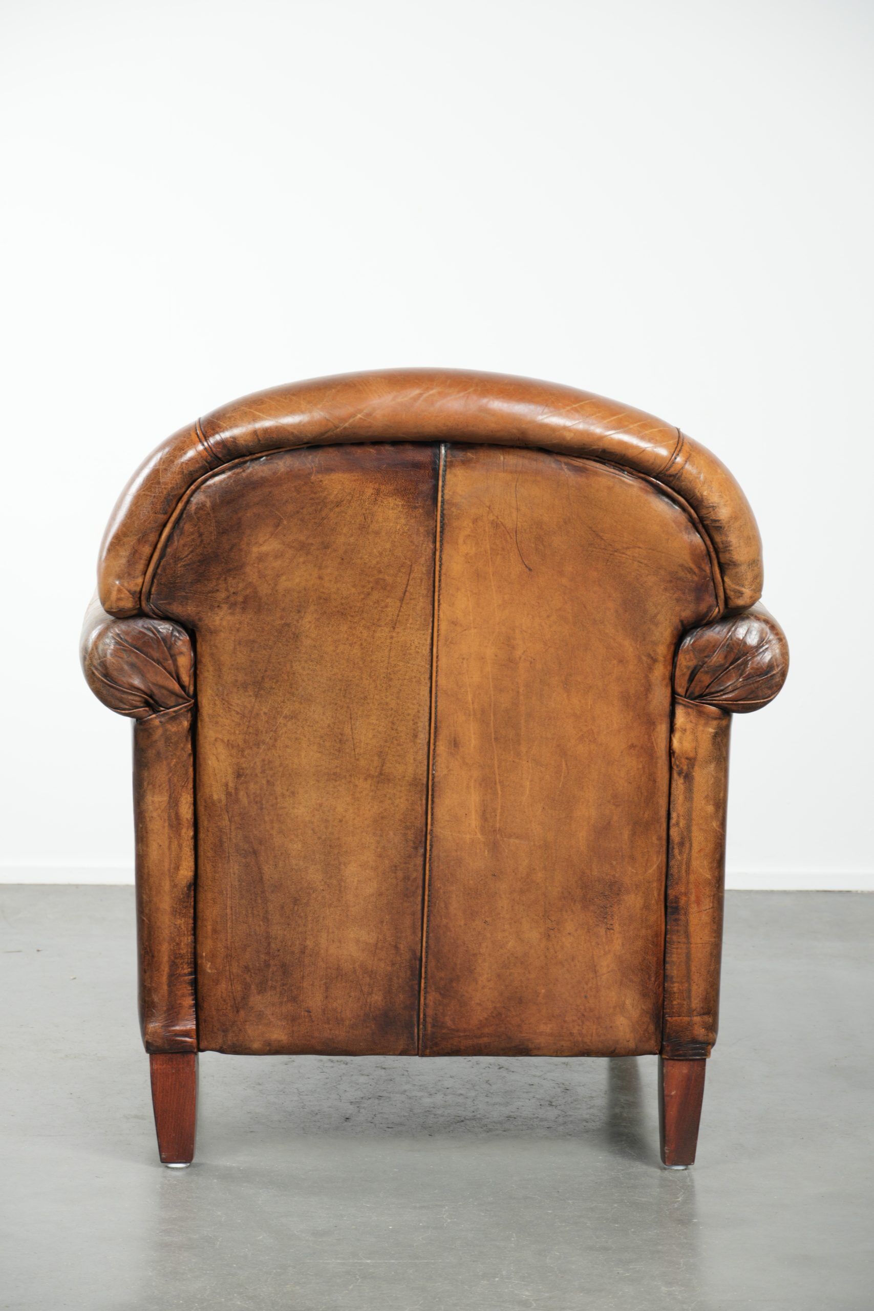 Sheepskin armchair with a beautiful vintage look and decorative nail finish