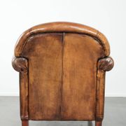 Sheepskin armchair with a beautiful vintage look and decorative nail finish