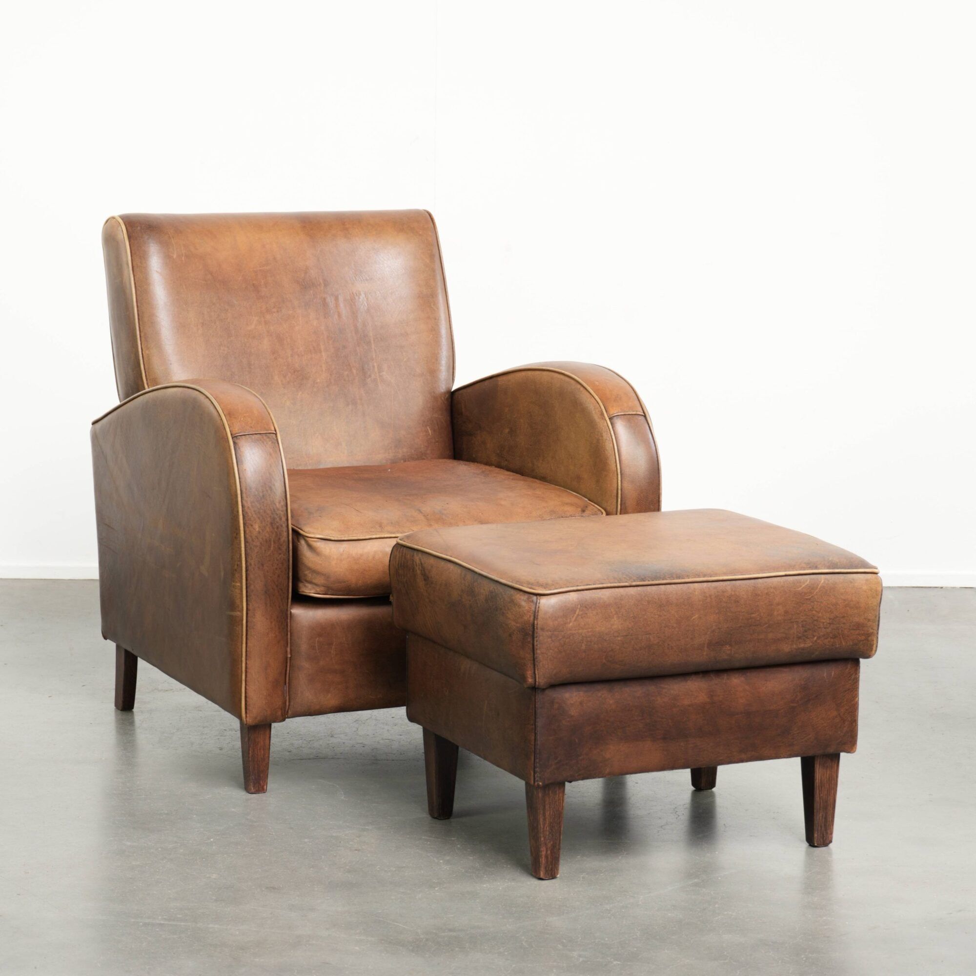 Set of a sheepskin armchair and ottoman finished with matching piping