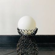 Black wrought iron lamp with a white glass globe.