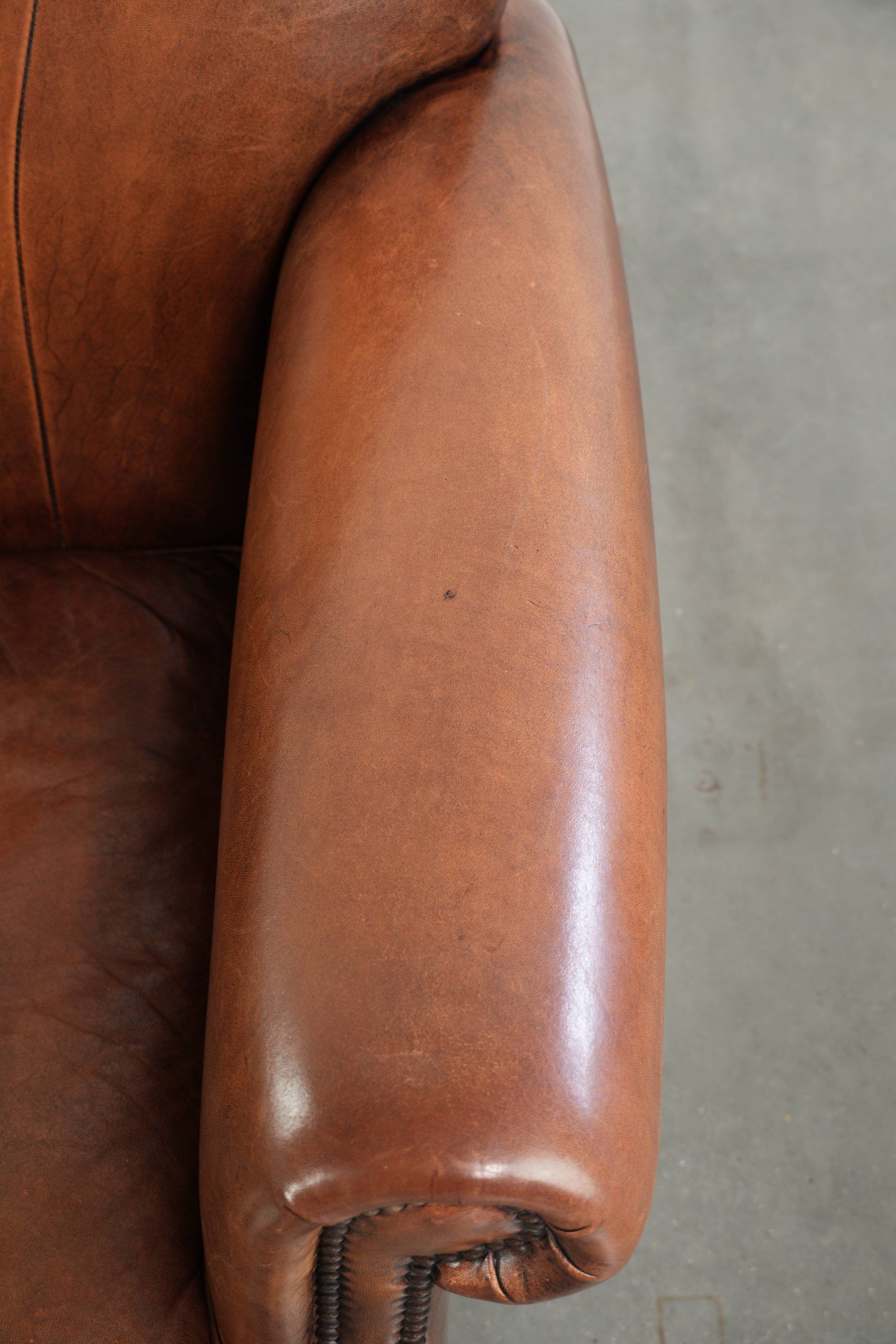 Sheepskin armchair with comfortable seat and finished with decorative nails