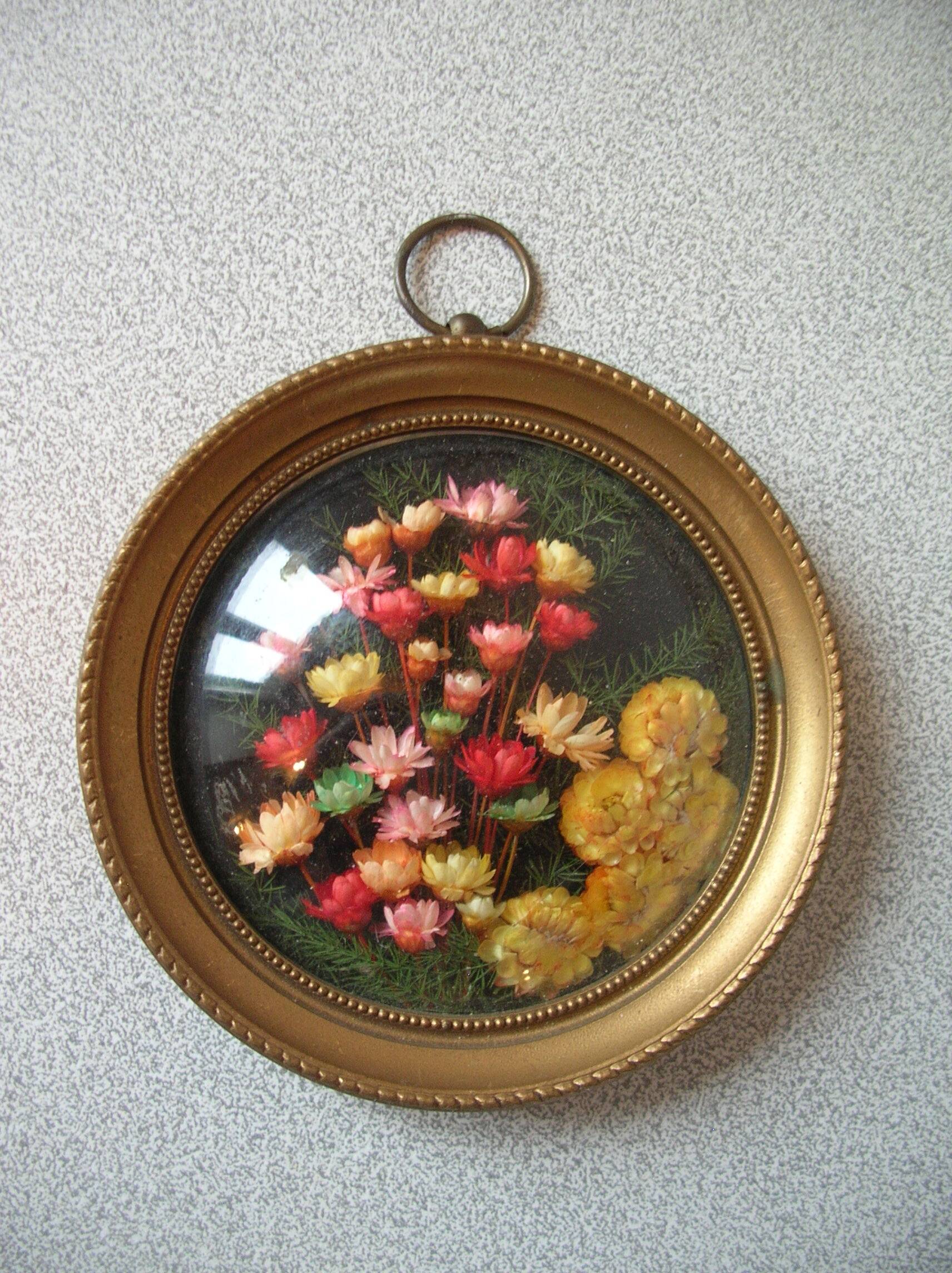 Old medallion frame bouquet of dried flowers glass and plastic retro decoration