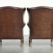 Ensemble de 2 fauteuils à oreilles en cuir de vache de style anglais.