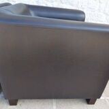 2 club armchairs with a chocolate faux leather seat and backrest and wooden legs.