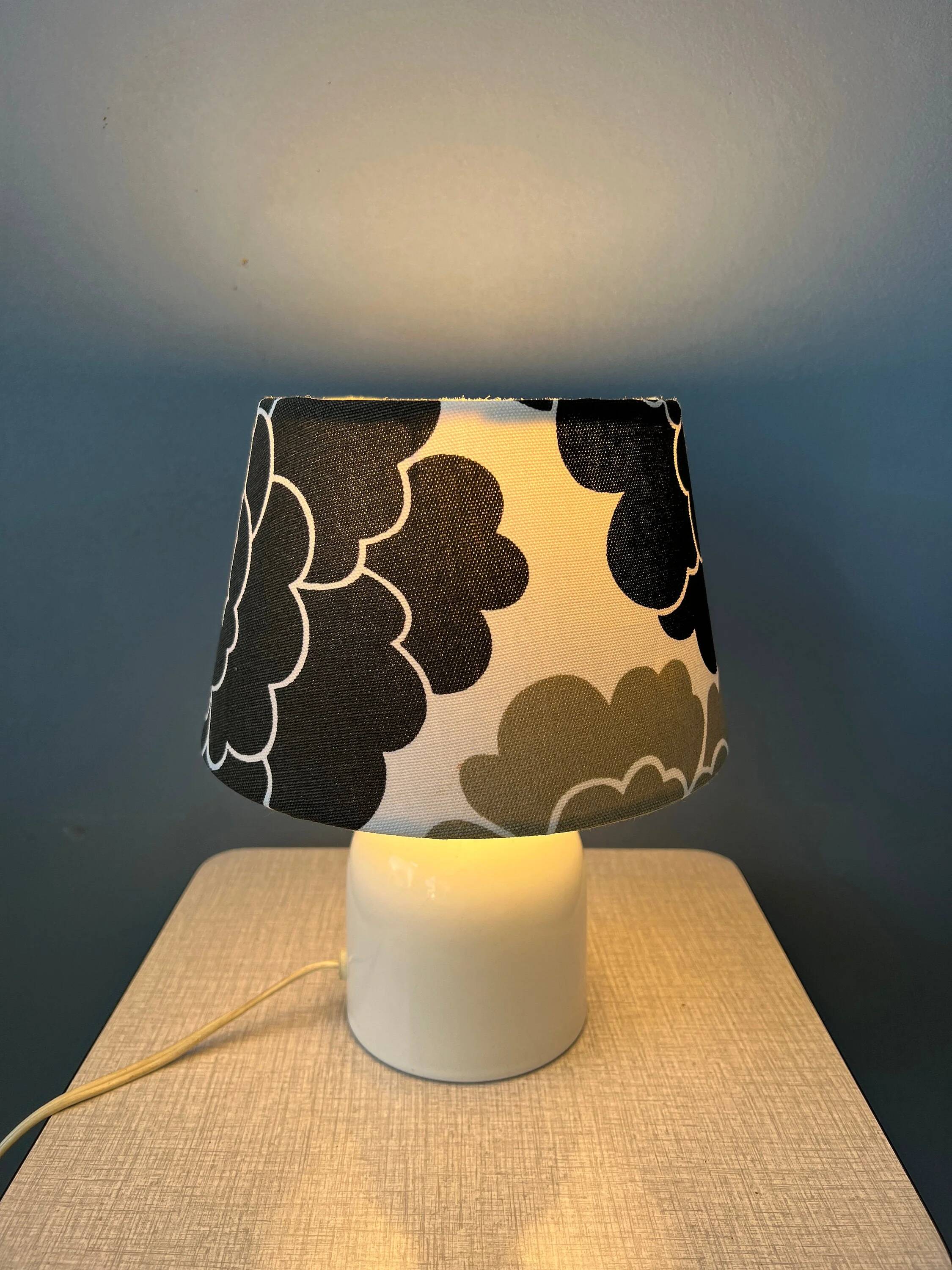 Small Space Age table lamp with a porcelain base and black and white flower shade.