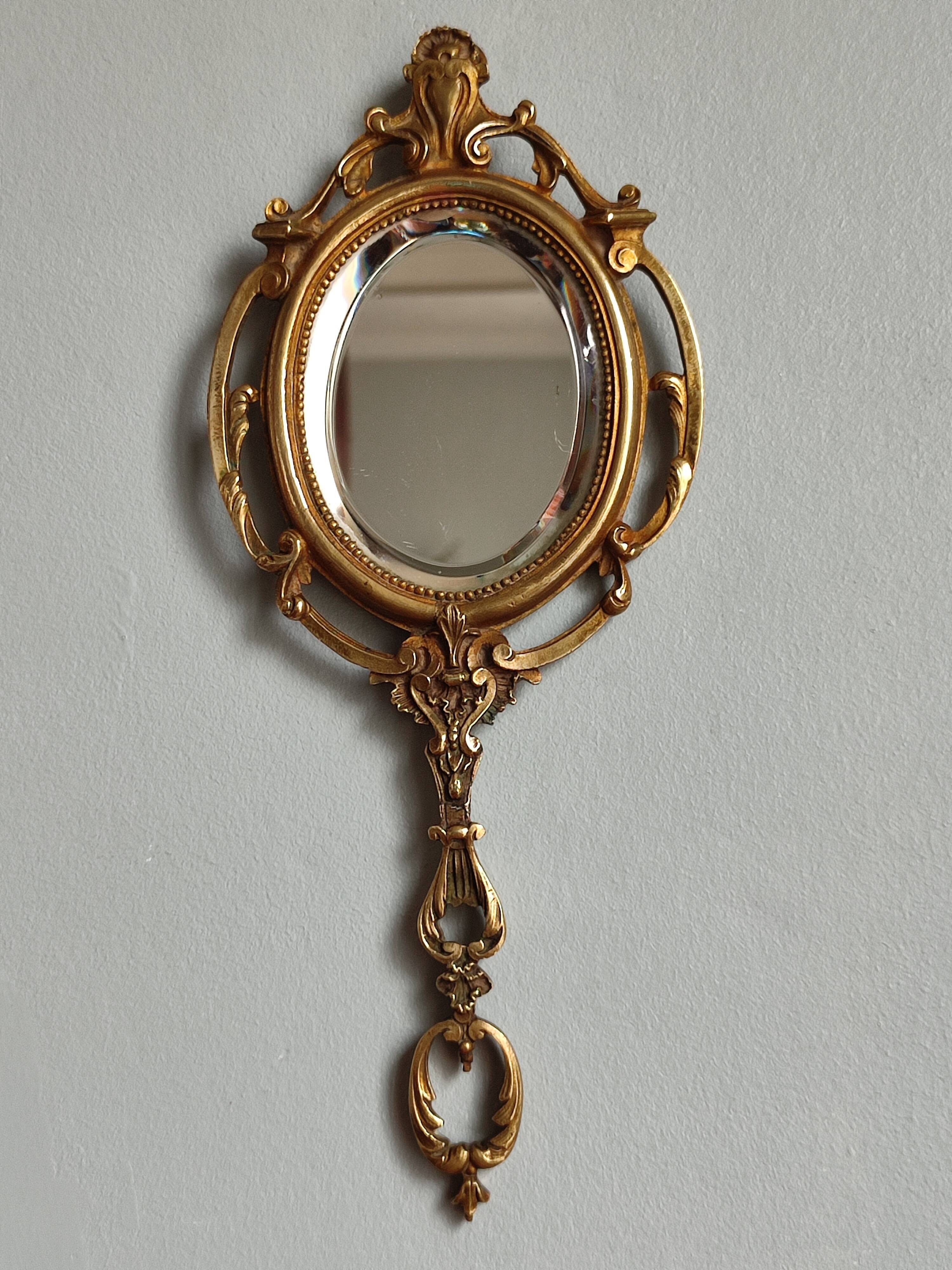 Antique hand-facing mirror in bronze and beveled glass