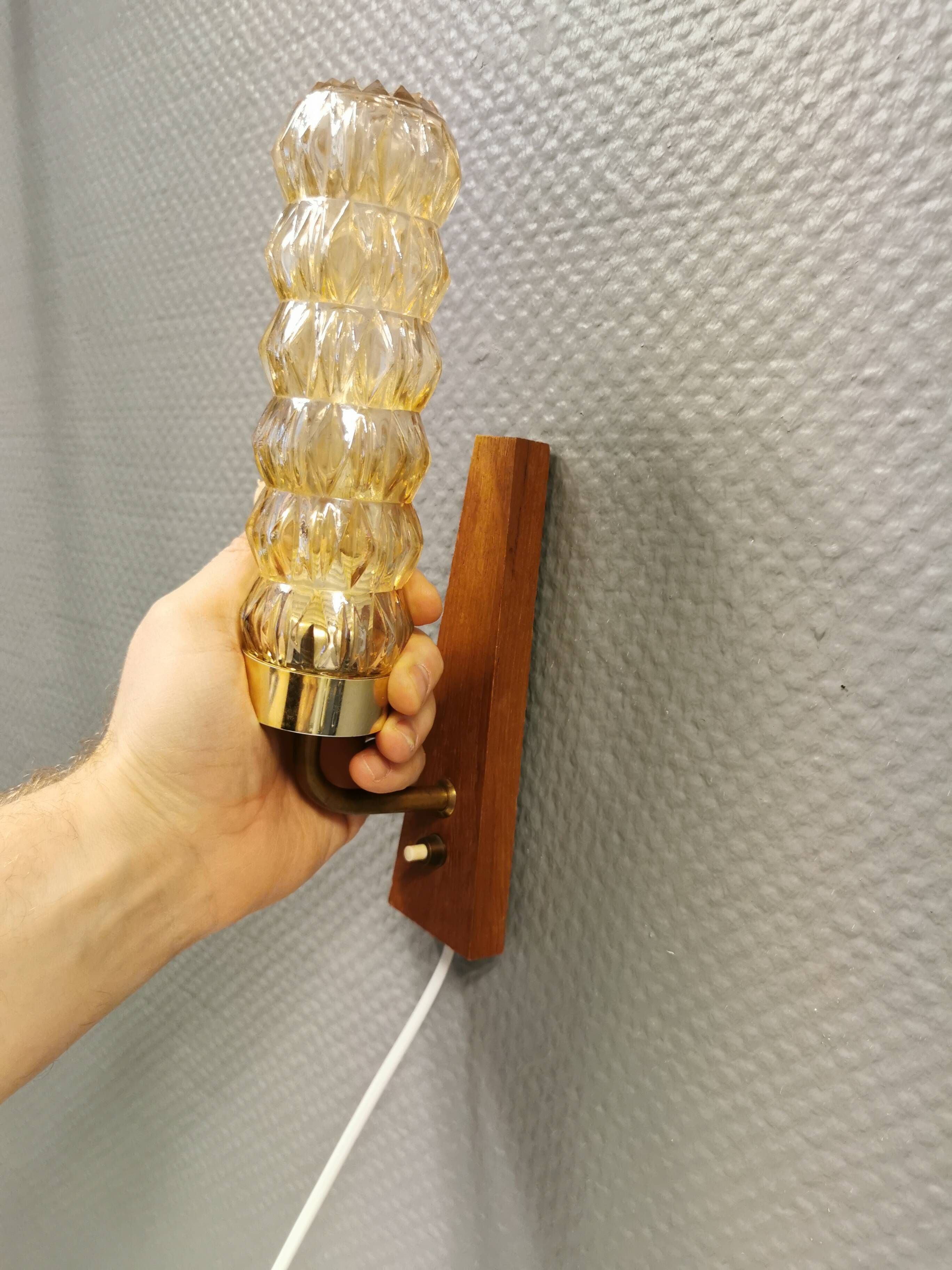 A set of Danish wall lights in champagne coloured glass with brass and teak.