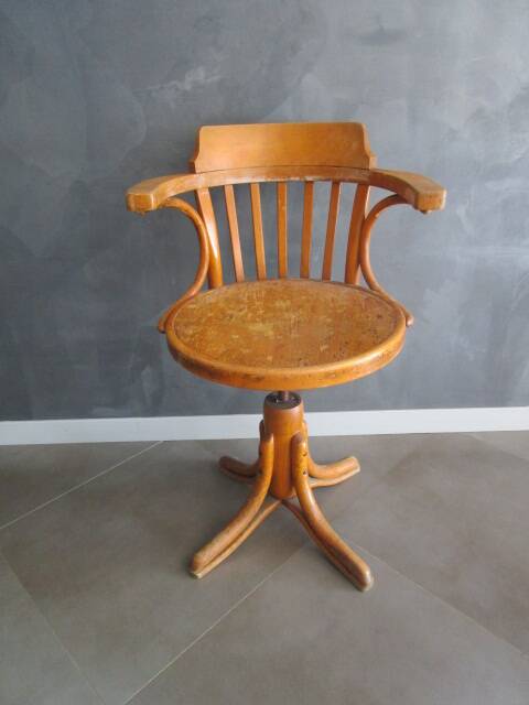 Old swivel office armchair in curved wood