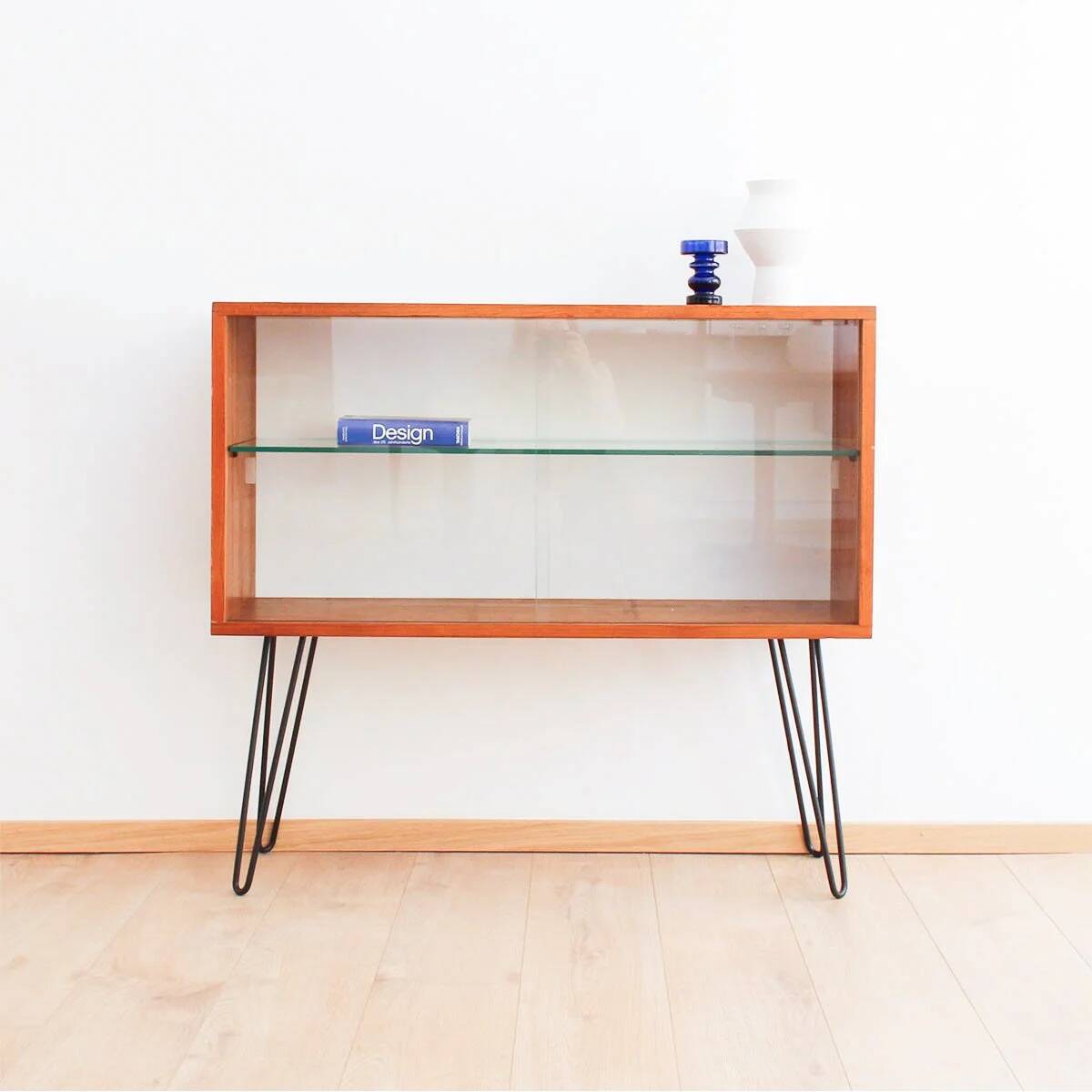 Teak display cabinet with black hairpin legs.