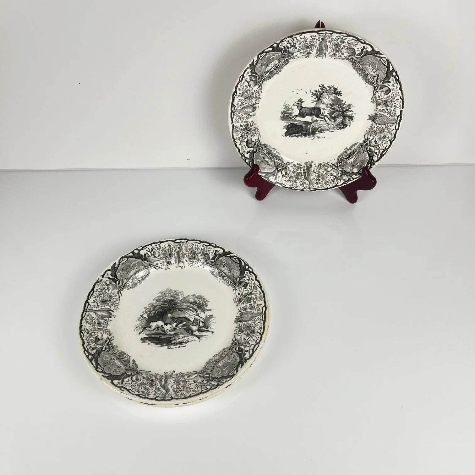 Set of three antique Sarreguemines U&C plates with hunting decoration from 1850 - 19th century black earthenware featuring a doe, chamois, and fox.