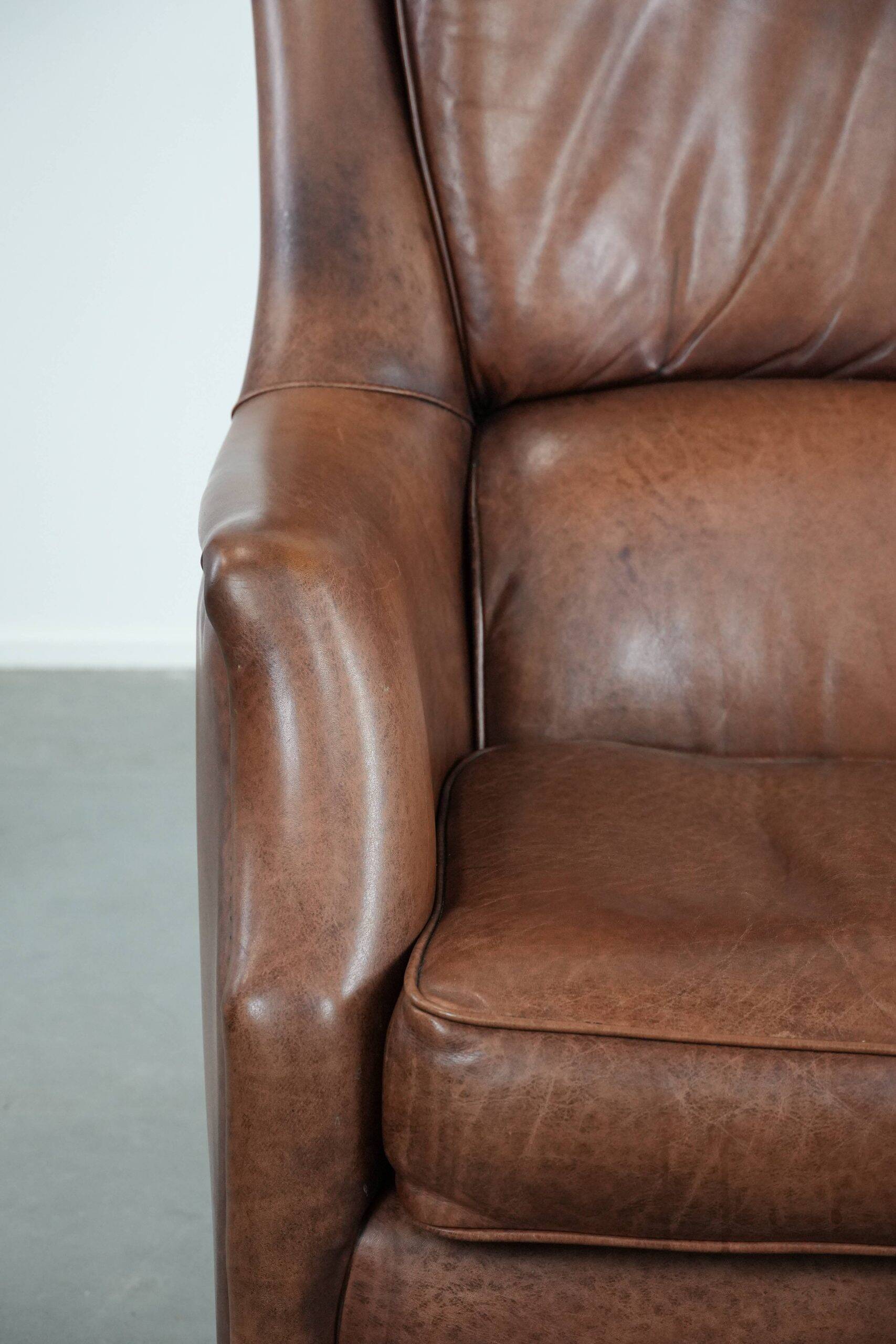 Cognac brown cow leather armchair with decorative nail finish