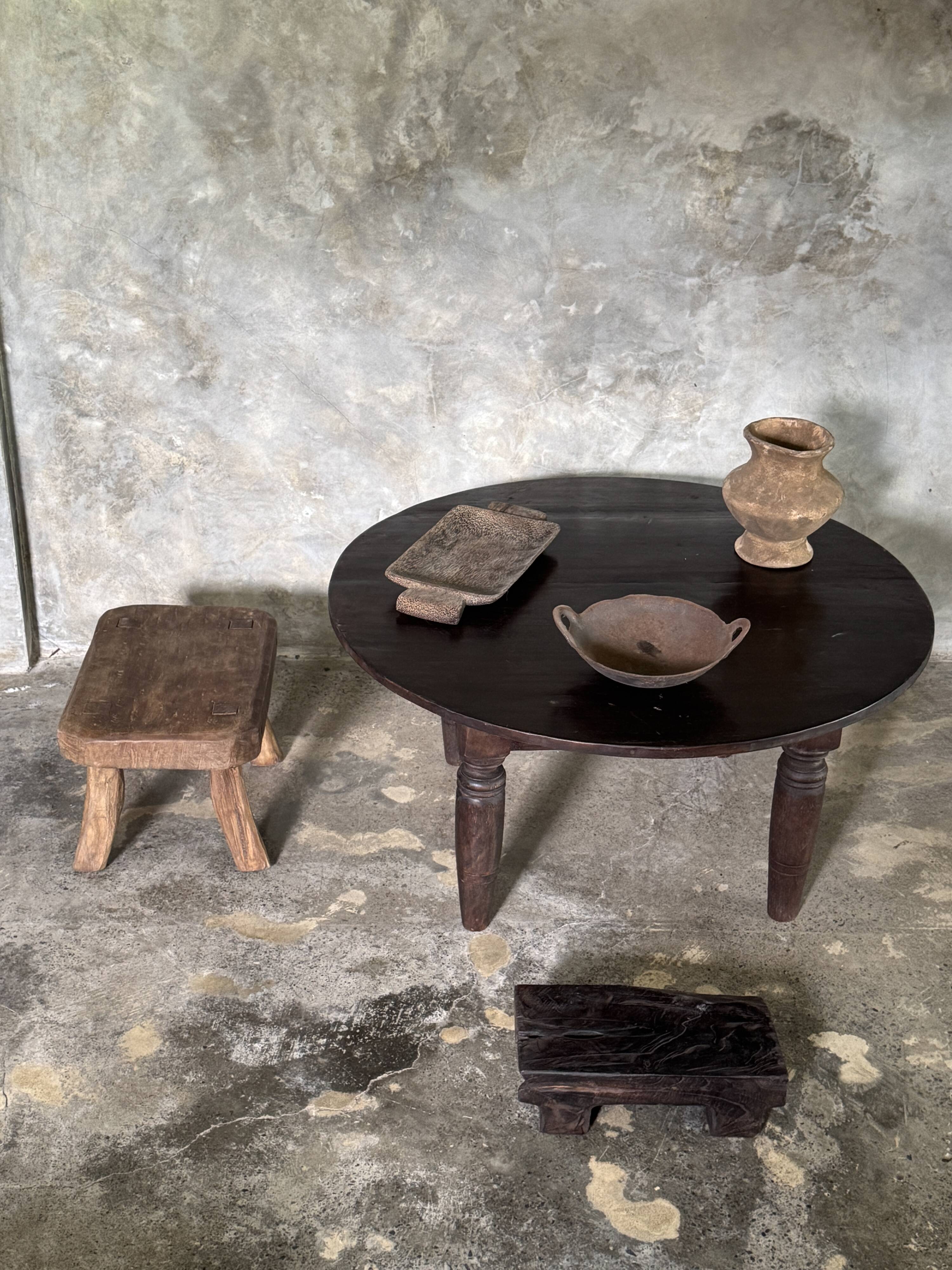 Antique round coffee table in Indonesian teak with turned legs.