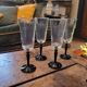 4 clear glass flutes with black stems. 1960–1970. 4 clear glass flutes with black stems.