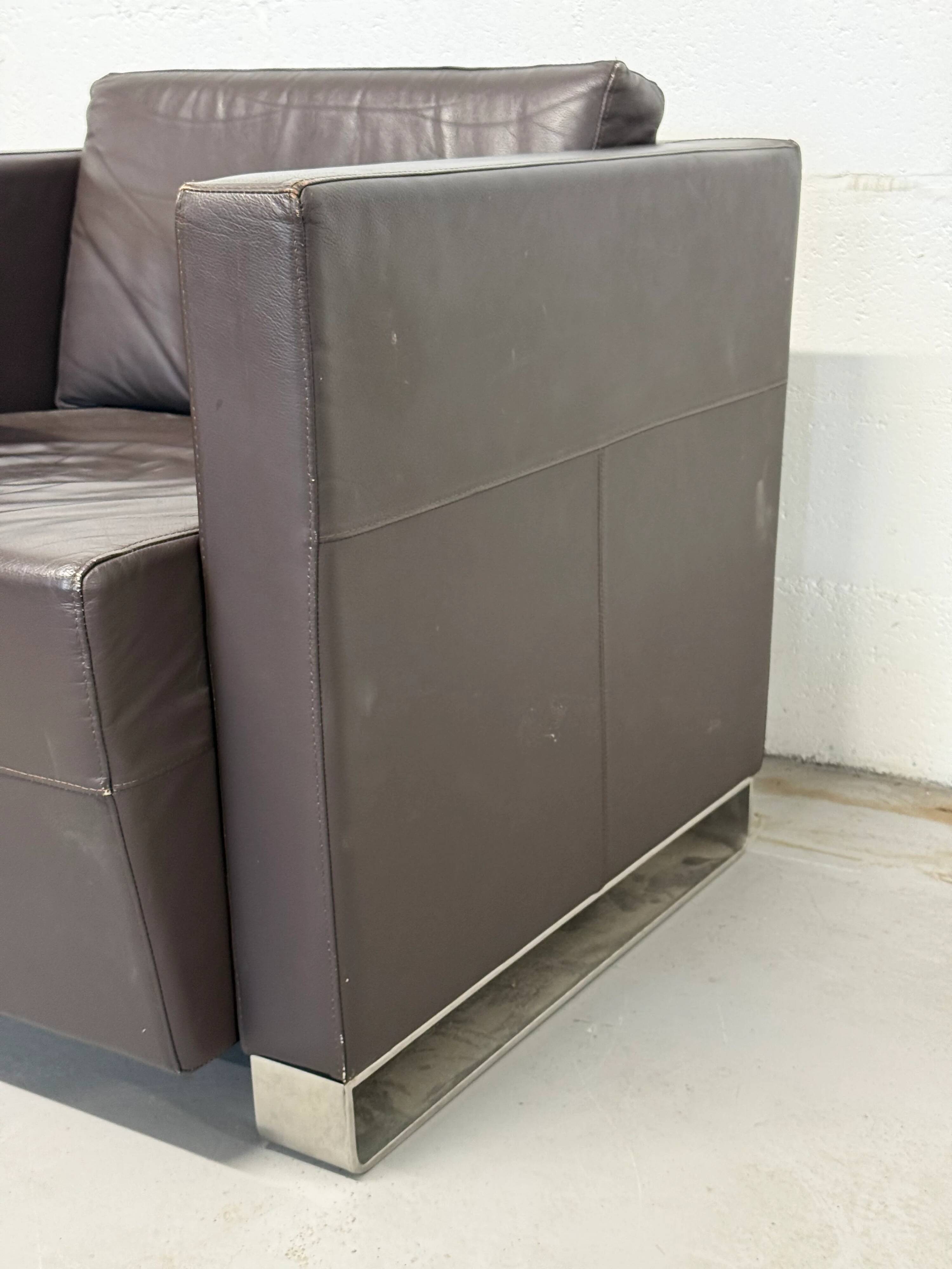 Vintage brown leather club armchair with a swivel side table.