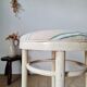 Vintage curved wooden stool in Baumann style, striped fabric seat.