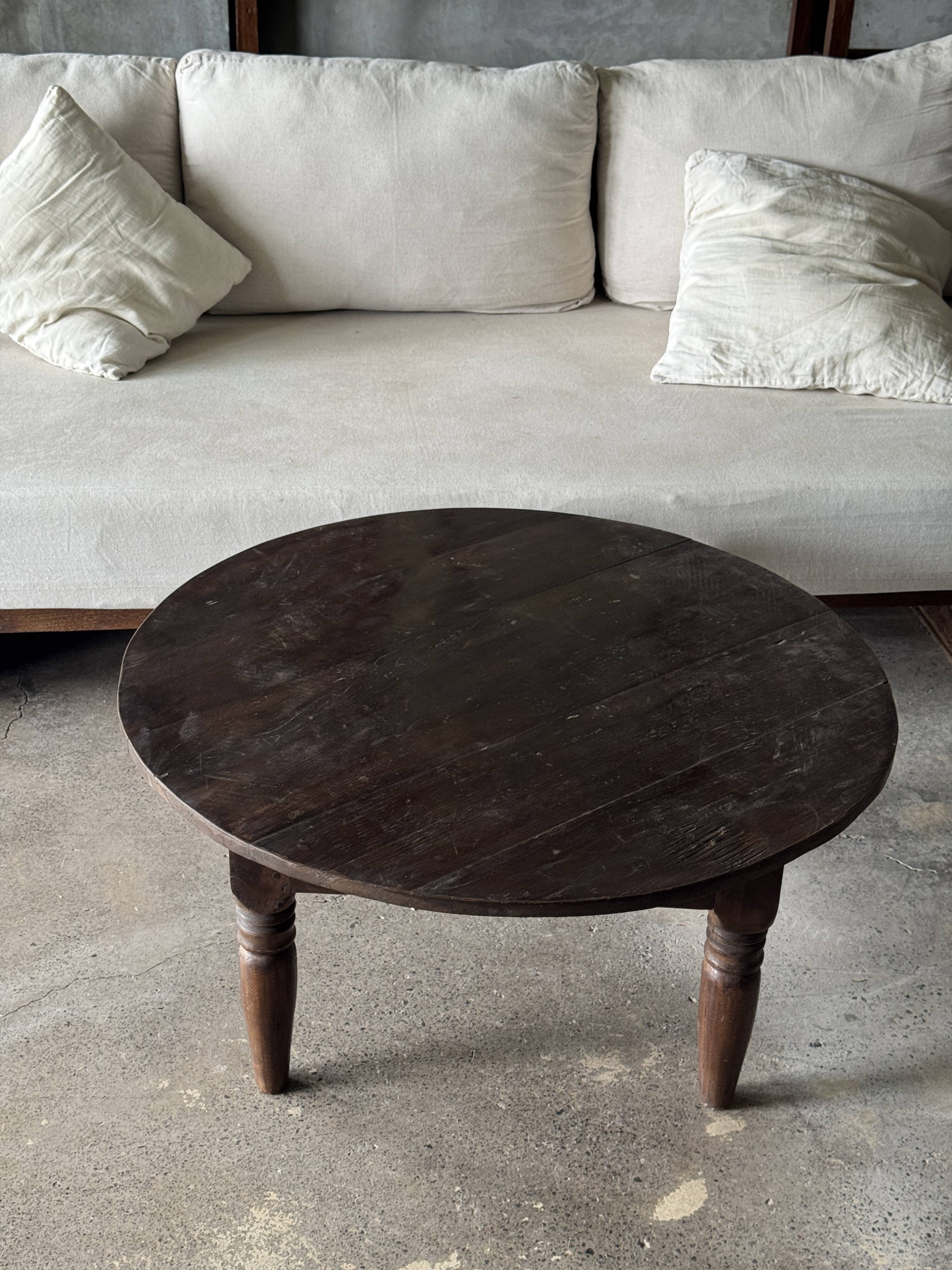 Coffee table, round antique Indonesian teak table with straight legs.