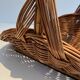 Woven Rattan Log Holder in a Semi-Round Shape with a Central Arched Handle.