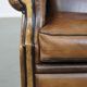 Vintage sheepskin wingback chair finished with black piping