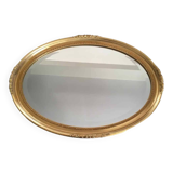 Beveled oval mirror with carved gilded wood frame