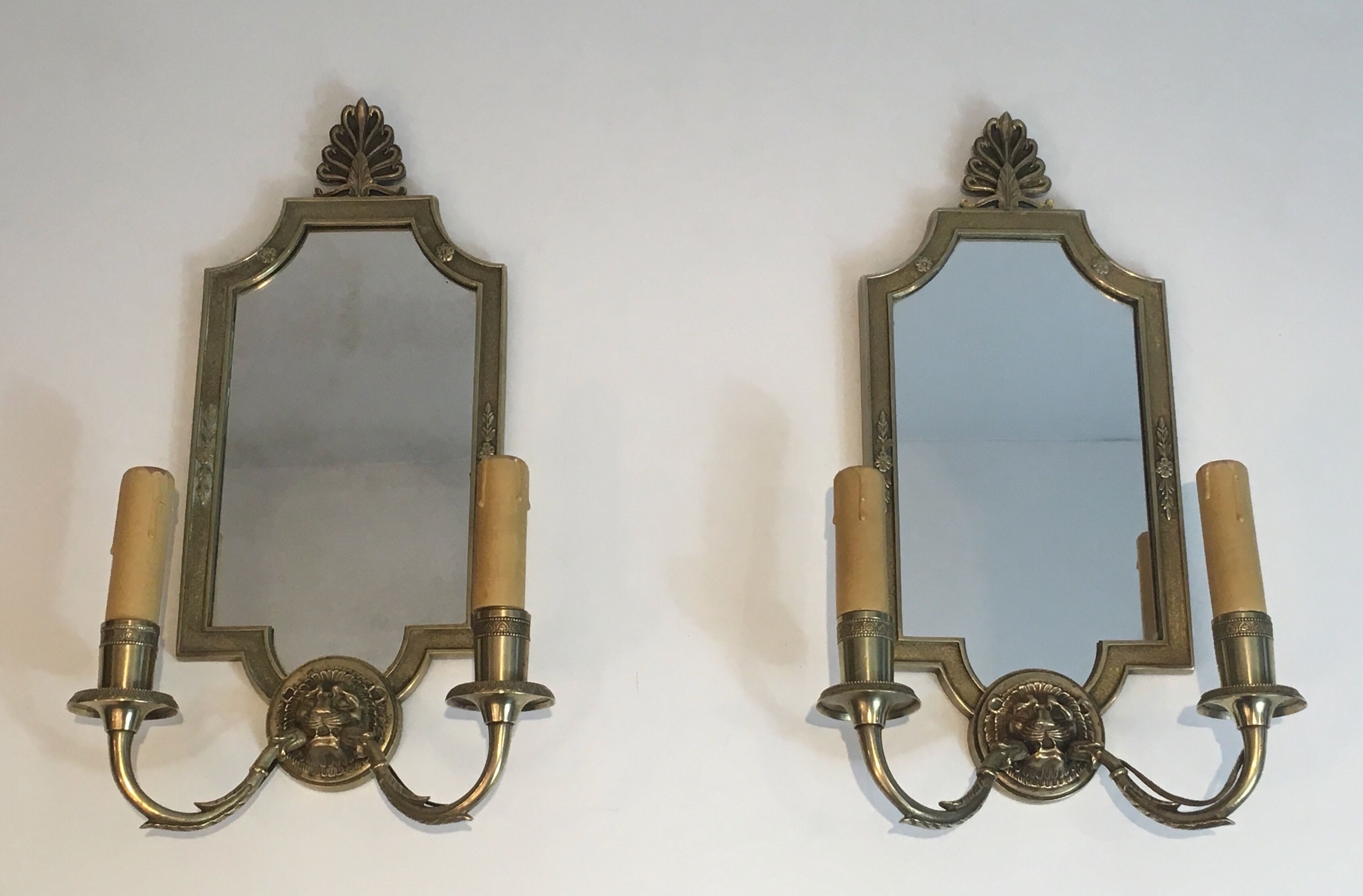 Pair of mirror and bronze wall lamps with lions' heads, french work. around 1940