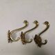 Three old and beautiful brass hooks with decorative motifs