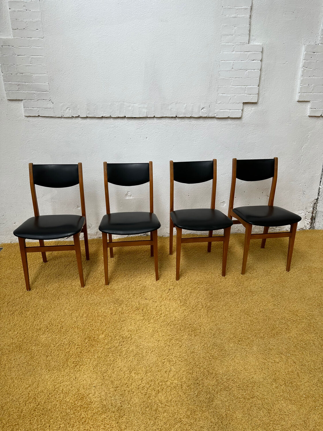 4 Scandinavian chairs in teak and black faux leather.