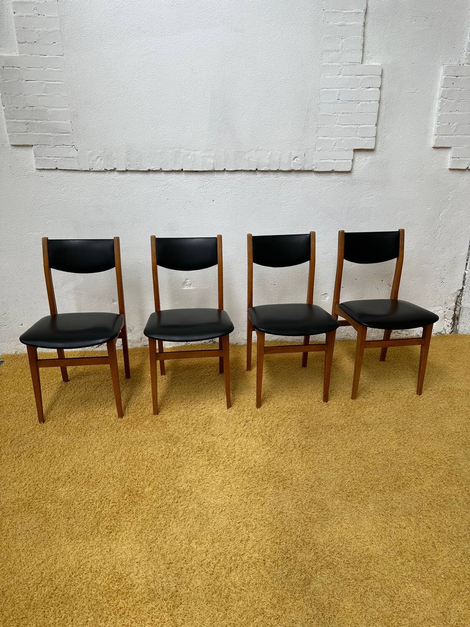 4 Scandinavian chairs in teak and black faux leather.