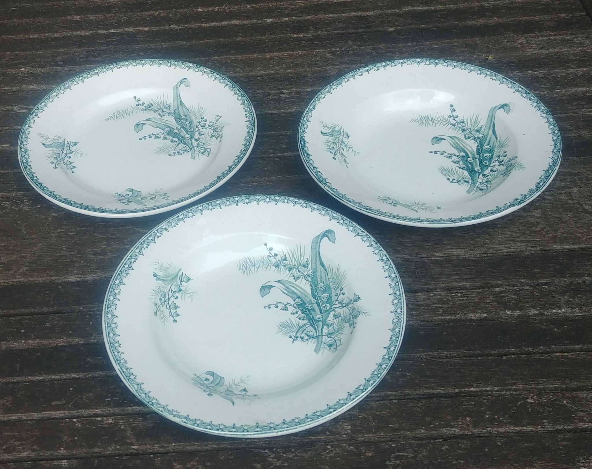 Set of three iron earthenware plates from the St Amandinoise earthenware factory, lily of the valley model.