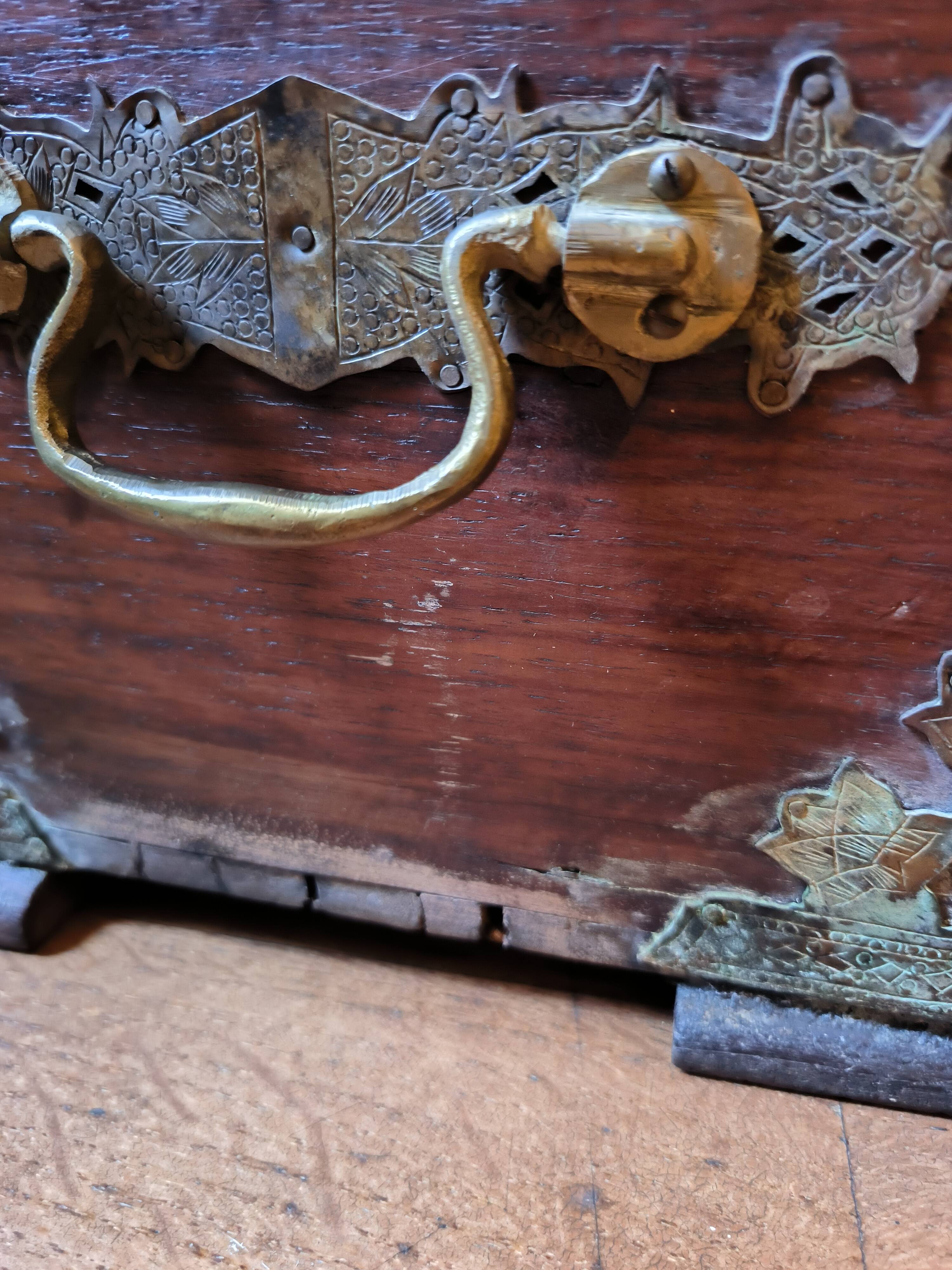 Old Indian wooden wedding chest decorated with chiseled brass plaque. India late 19th/early 20th