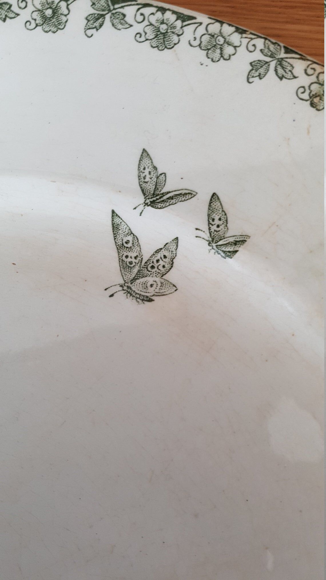 White and green ceramic dish decorated with flowers and butterflies