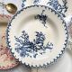 10 mismatched vintage soup plates in blue, green, and red ironstone