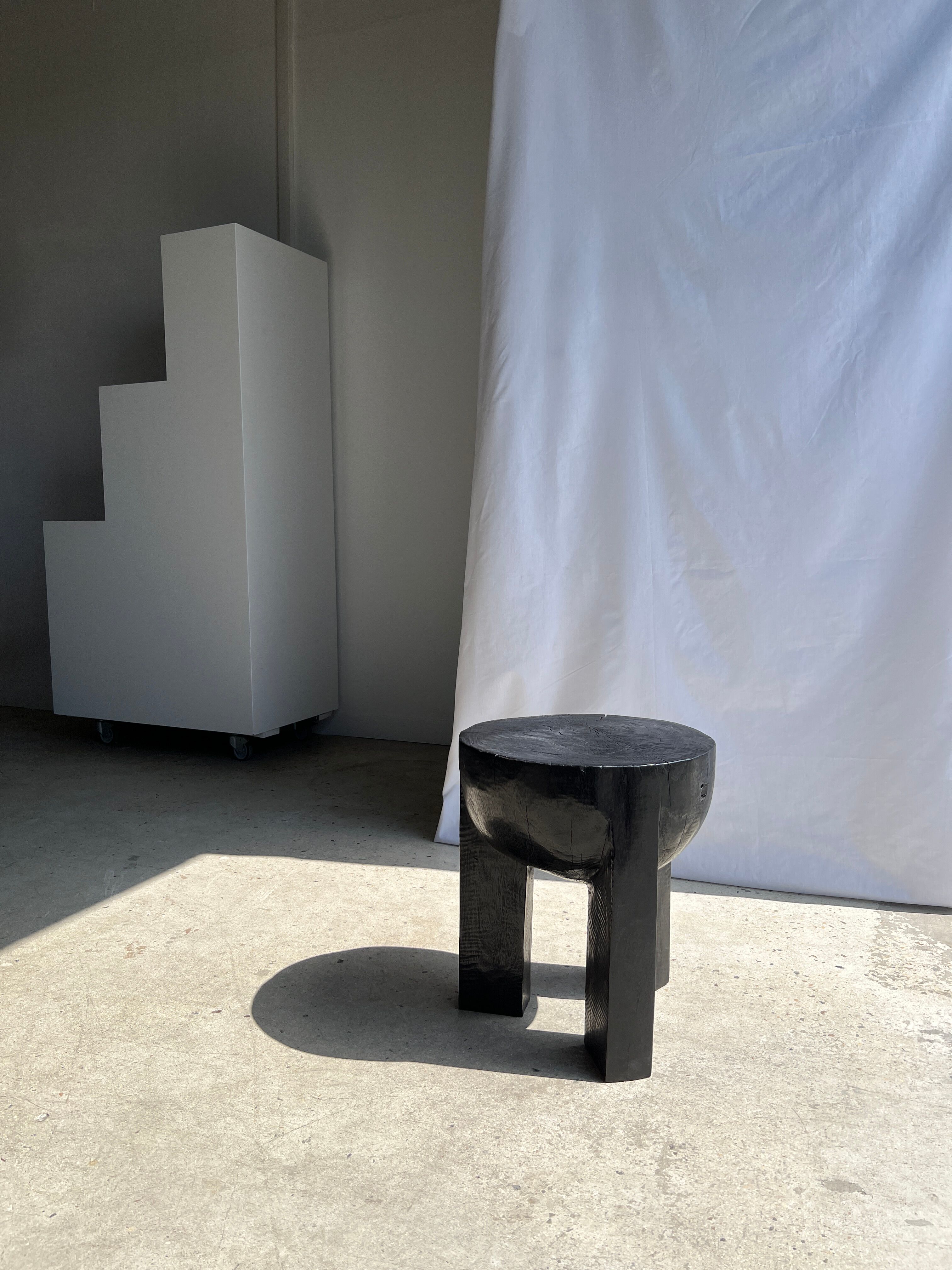 Black mango wood tripod side table with a semi-spherical top, height: 45 cm, diameter: 44 cm.