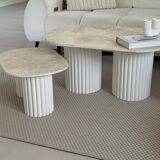 Oval coffee table duo travertine and white fluted wooden legs.