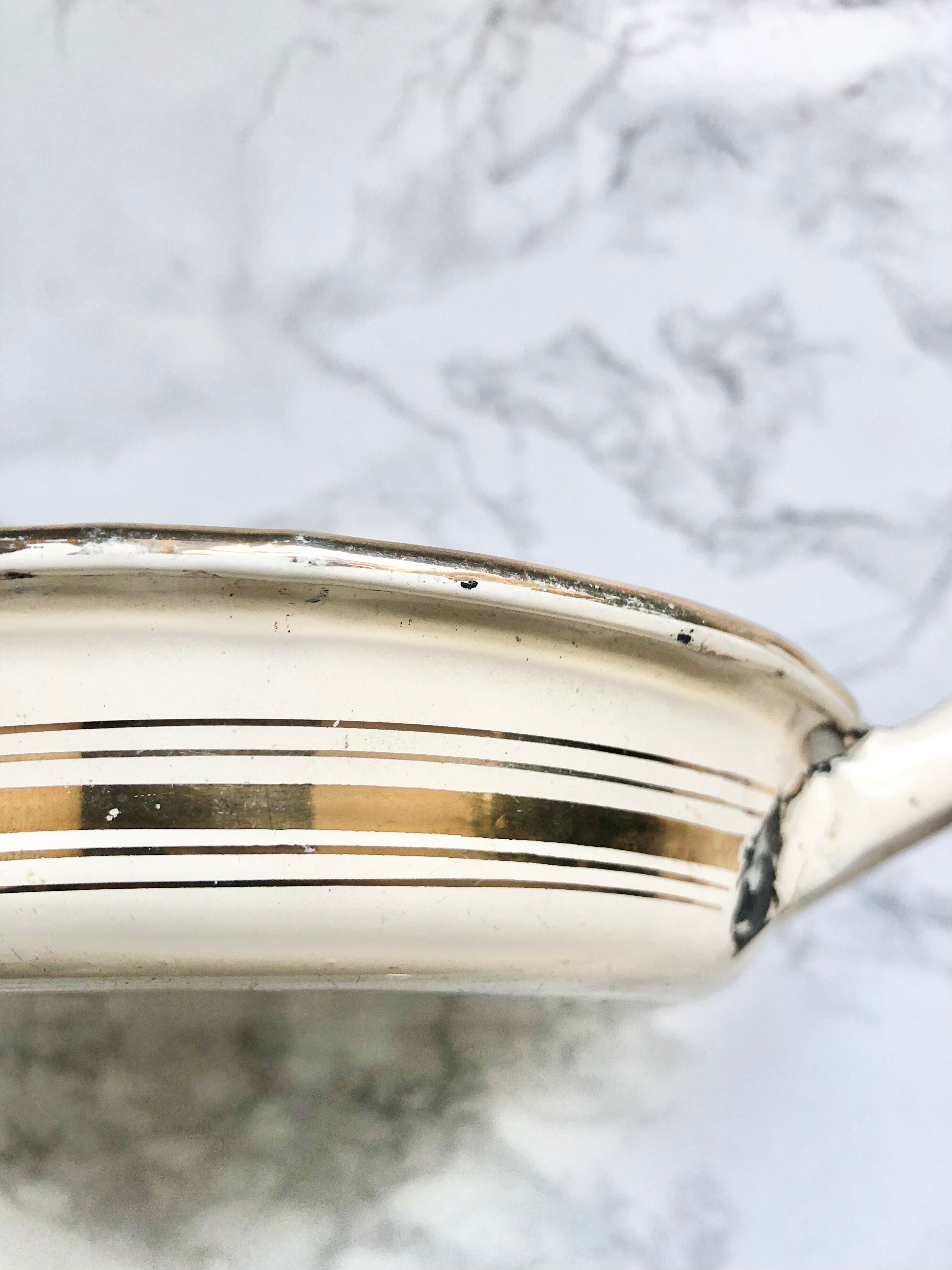 Old egg dish in creamy white and golden enamelled sheet